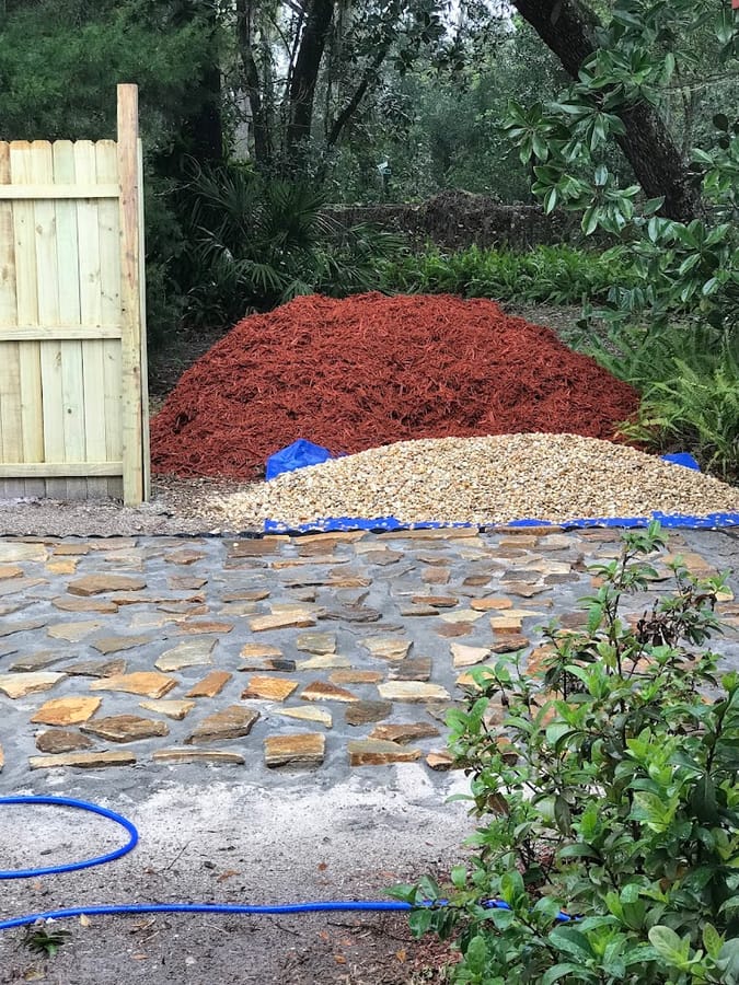 Red mulch and gravel delivered beside a flagstone path